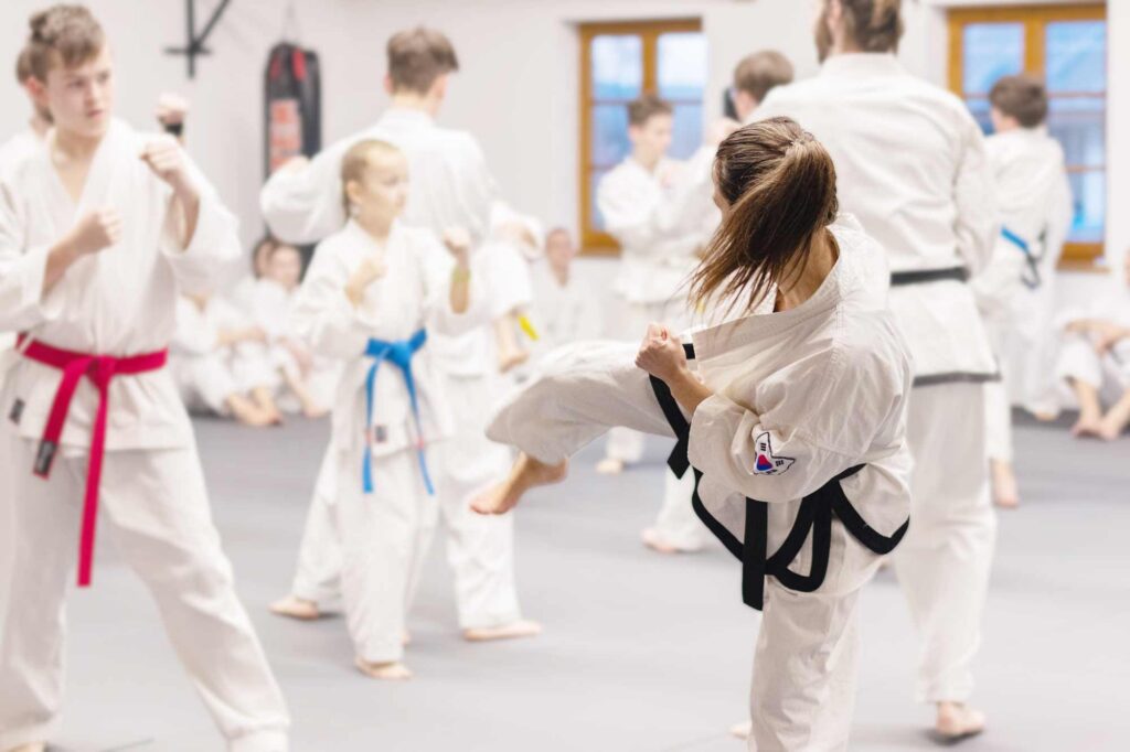 Eine Taekwondo-Triningstunde. Eine junge Frau tritt.